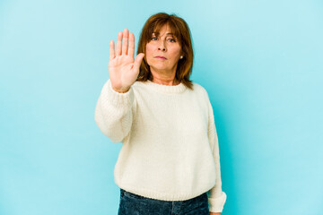 Senior caucasian woman isolated standing with outstretched hand showing stop sign, preventing you.