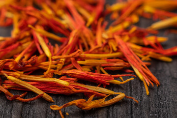 close up of dry saffron stigmas on a dark wodden background