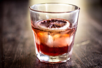 Old fashioned glass negroni cocktail alcohol drink beverage with orange slice and bokeh background