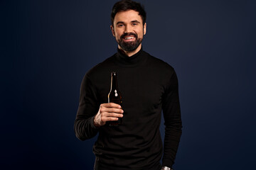 Photo of amazing guy with brown beer ale bottle spending great time wear trendy sweater isolated on Pacific Blue background