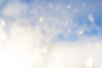 Blurred sunlight overlay effect. Rainbow rays of light on a blue sky background. Natural bokeh light effects