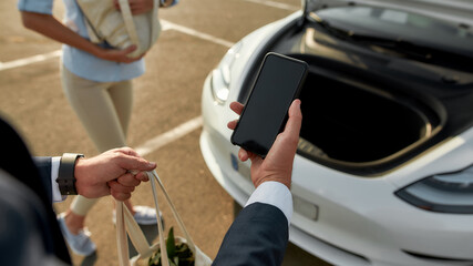 Smartphone used for electric car hood opening after shopping