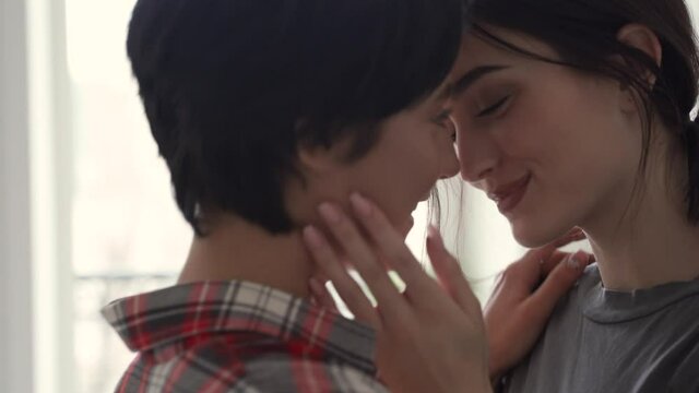 Two young affectionate gen z women lesbian lgbtq couple dating standing at home together, kissing passionately, hugging enjoying intimate tender sensual moment, bonding in apartment. Lgbt love concept