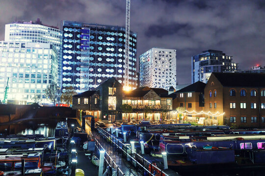 At night, boats are parked in docks. To align with Birmingham's vintage-modern atmosphere, docs are brightly illuminated. Reflection of modern buildings can be seen on calm waterways.