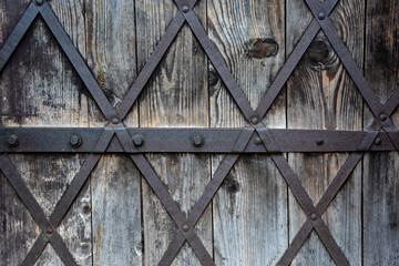 close-up of an old castle wooden door where we can see there is metal wire