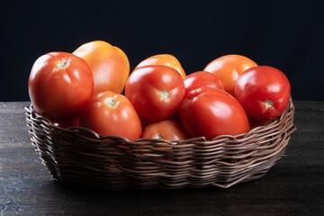 Red tomato in basket with black background