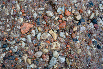 small colored stones on the ground in the thaw are wet and contrasting