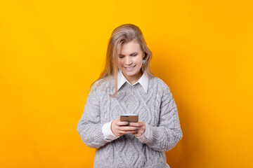 Photo of young woman in casual typing a message.