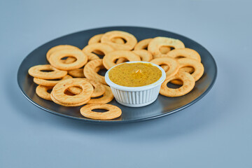 Cracker rings with a sauce on a ceramic plate