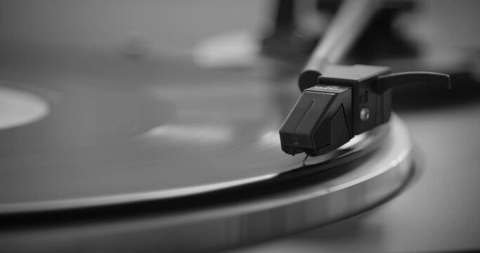 Black and White. The needle goes down on a vintage vinyl record. The vinyl record is spinning. The needle plays on a vintage vinyl record. Old turntable