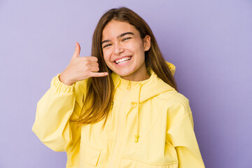 Young skinny caucasian girl teenager on purple background showing a mobile phone call gesture with fingers.