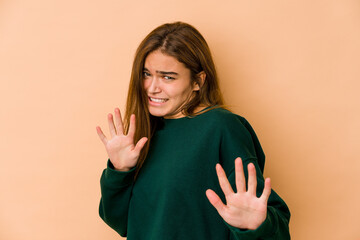 Young skinny caucasian teenager girl rejecting someone showing a gesture of disgust.