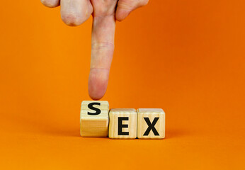 Sex with an Ex symbol. Hand turns a cube and changes the word 'ex' to 'sex'. Beautiful orange...
