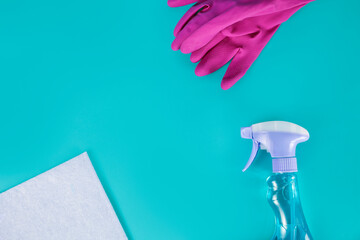 Washing rags with latex gloves and sprayer on a blue background. Top view. Cleaning products and supplies concept.