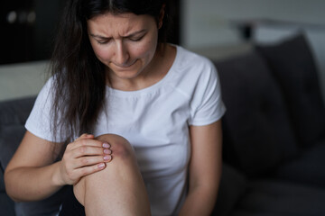 Close-up of a person massaging an injured knee joint. Bruise on the knee. Leg pain