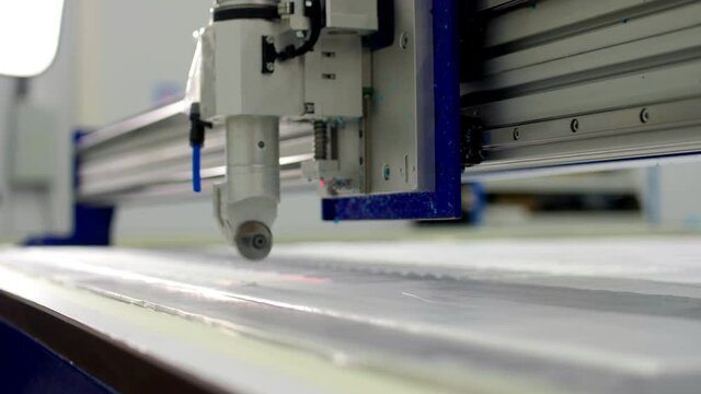 Cutting machine makes details for medical clothes on table