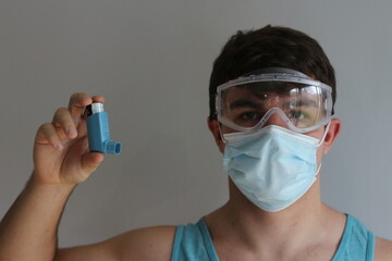 man in full ppe shows how to use a rescue inhaler
