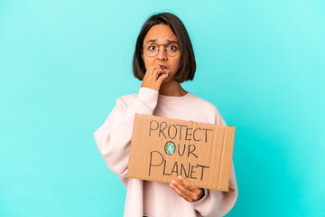 Fototapeta na wymiar Young hispanic mixed race woman holding a protect our planet cardboard biting fingernails, nervous and very anxious.