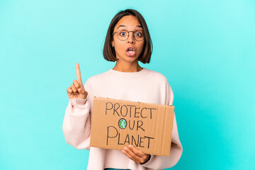 Fototapeta na wymiar Young hispanic mixed race woman holding a protect our planet cardboard having some great idea, concept of creativity.