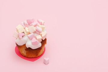 cupcake with hearts from marshmallow on a pink background with little heart on near the muffin