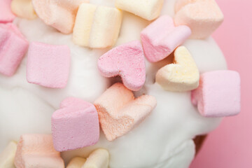 cupcake with hearts from marshmallow on a pink background closeup
