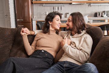 Couple hugging and looking at each other at the sofa