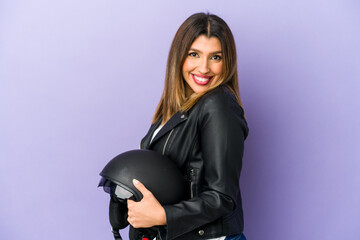 Young indian motorbiker woman isolated looks aside smiling, cheerful and pleasant.