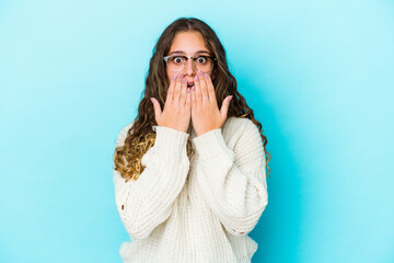 Young caucasian curly hair woman isolated shocked, covering mouth with hands, anxious to discover something new.