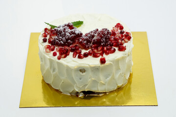 Cake sprinkled with pomegranate berries. Cake on white backgroun