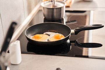 Scrambled eggs in frying pan on electric stove