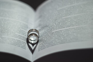 Fototapeta premium Wedding rings lie in open book.