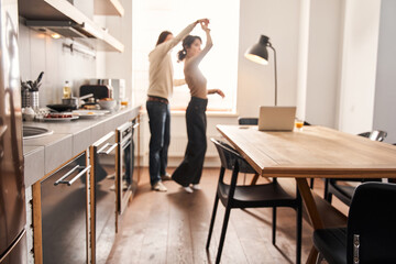 Loving couple embracing and dancing at the cozy kitchen
