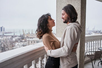 Female being embraced by her man at the balcony