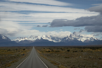 Asphalted road with the peaks of a rocky and snowy mountain on the horizon. Fitz Roy mountain in Argentina horizontal Photograph