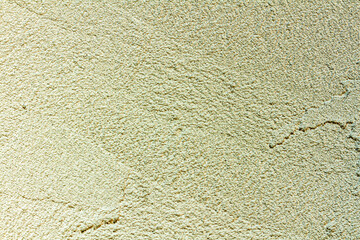 rough plaster facade painted yellow as a texture or background