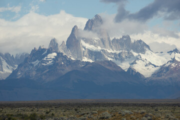 Asphalted road with the peaks of a rocky and snowy mountain on the horizon. Fitz Roy mountain in Argentina horizontal Photograph