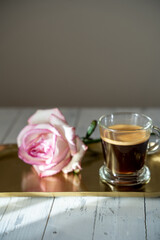 a a cup of coffee with a rose on a gold tray. Romantic coffee. sunny morning. High quality photo