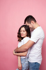 young cheerful caucasian couple together having fun on pink background, guy ang girl modern relationship, lifestyle people concept