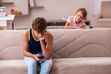 Boy and his small sister staying at home during pandemic