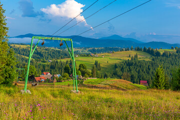 Summer view of hill with elevator for ski tourists. Mountains landscape background