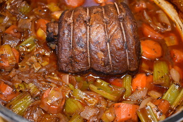 British slow cooked beef brisket casserole with carrots celery onions bay leaf. Briskets are cheap cut of beef making it perfect for long cooking which results in tender meat and rich wine thick gravy