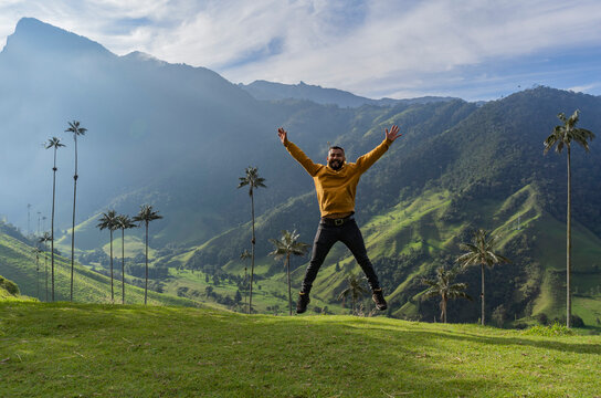A hiker man jumping. young hiker traveling alone. young man in cocora valley