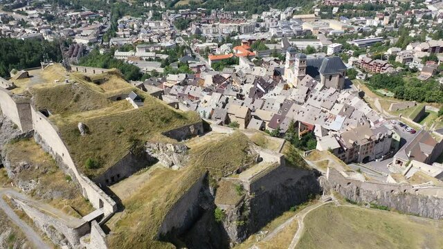 Aerial view of French fortified town of Briancon overlooking ancient fortress on hilltop and two belfries of parish church 