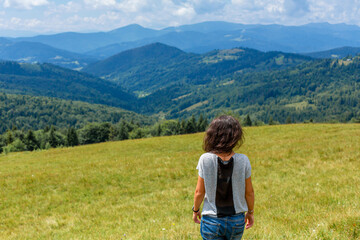 Fototapeta na wymiar Happy gorgeous girl enjoy mountain view stay on the hill with breathtaking mountain landscape