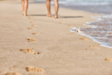 Traces on sandy shore of the sea from people walking.