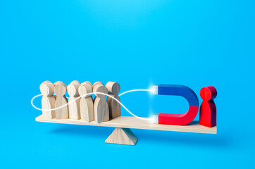 Red man with a magnet embraces and attracts people to his side. Recruiting, influencing. Political support. Leader and leadership. Attracting attention favoring yourself. Joining new member followers.