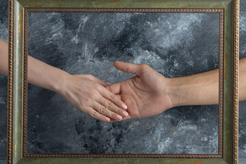 Male and female shaking hands in middle of picture frame