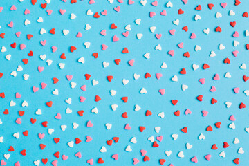 Valentine's Day background February 14th. Red, pink, white hearts confetti on bright blue background. Valentines day creative concept. Flat lay, top view, copy space.
