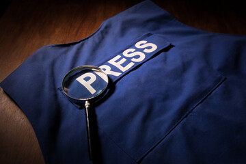 Media Journalism Global Daily News Content Concept. Blue journalist (press) vest in dark with backlight and fog. Media microphone on journalist vest.
