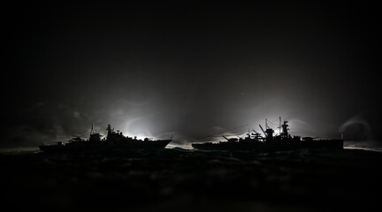 Silhouettes of a crowd standing at blurred military war ship on foggy background. Selective focus....